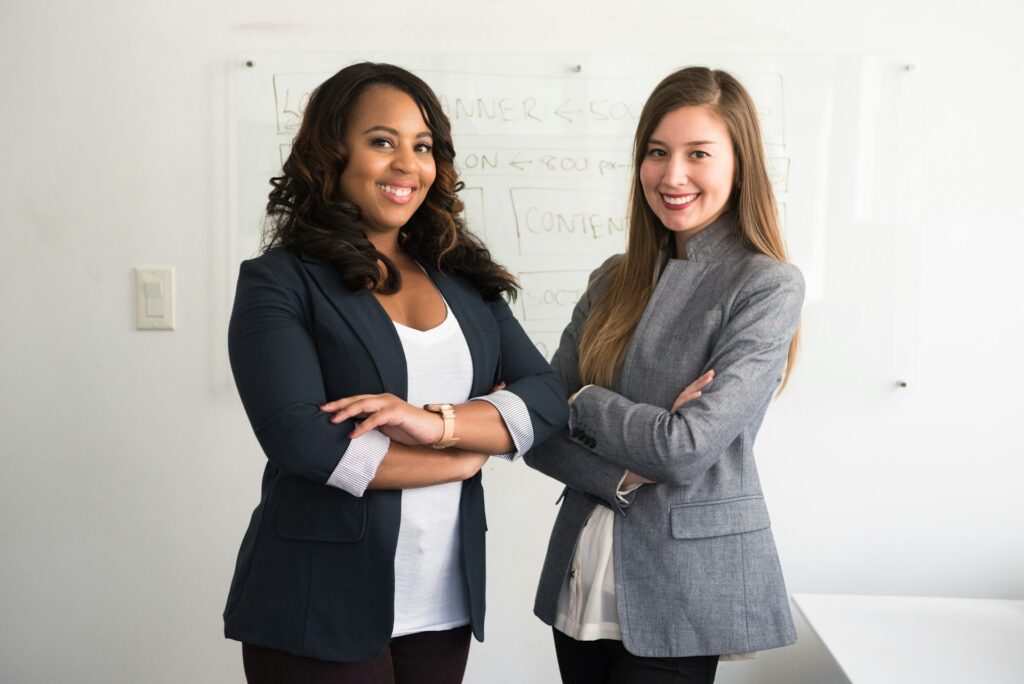 Mujeres posando orgullosas frente a la cámara dentro de la oficina.