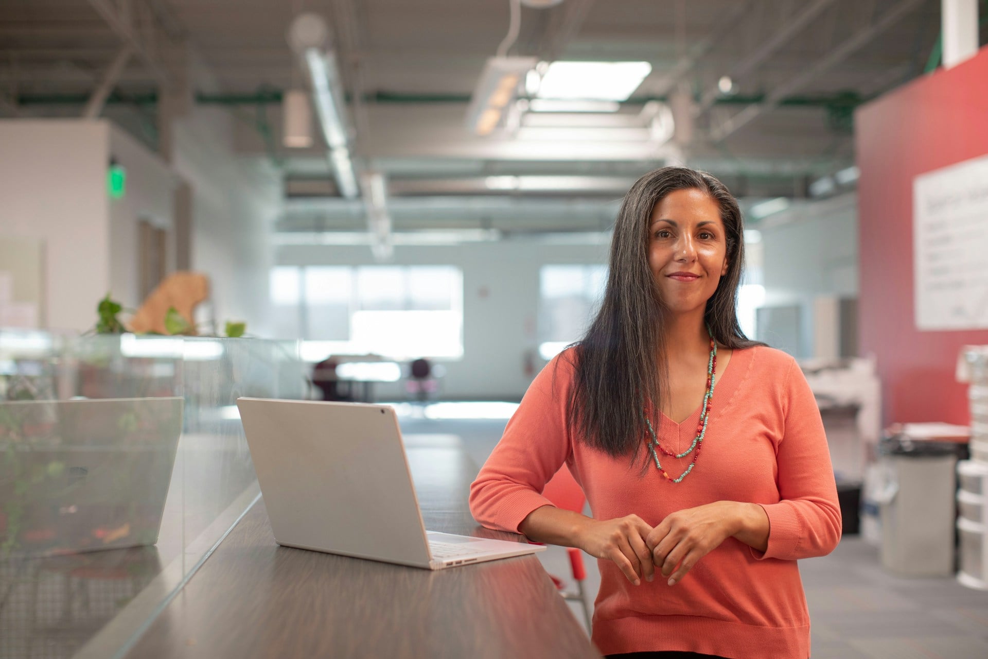 Mujer en la oficina posando orgullosa frente a la cámara. Foto de LinkedIn Sales Solutions en Unsplash